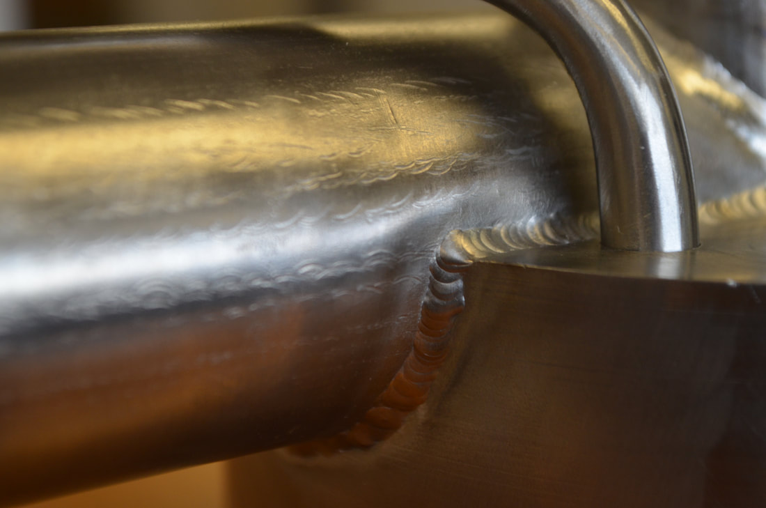 Close-up of ultra-high vacuum welds between the titanium tube and main vacuum chamber body. Meyer Tool's welder tested different TIG welding settings on practice pieces to dial in the proper titanium welding technique.