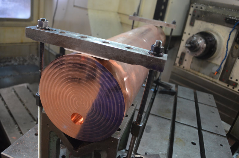 A precision hollow copper tuning rod for a DOE National Lab experiment.  The copper pipe and end caps were precision machined, copper TIG welded together then post-weld machined.  This image shows the rod getting post-machined in our 4-axis CNC horizontal mill.