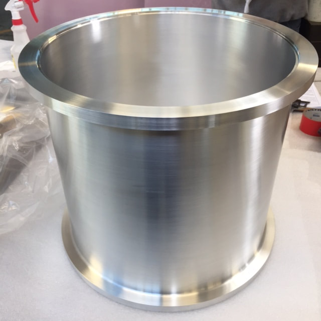 A typical, simple welded aluminum chamber. The welds on the interior of the flange have been ground flush with the ID. This classic shell and flange chamber design is most cost effective as a welded assembly.
