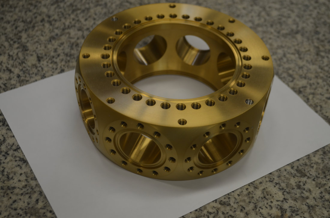 A small research vacuum vessel with many integrated ports and flanges. Small, complex vessels like this work great as hog-outs. The vessel body was machined from aluminum round bar and anodized after polishing.