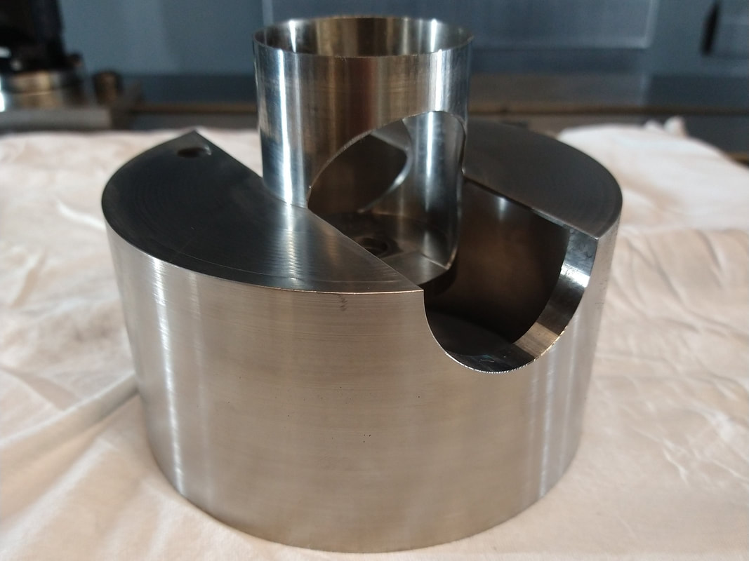 The main body of the vacuum chamber was precision machined from a single piece of solid titanium round bar. The body was designed with an integrated machined tube to reduce risky internal welds. The entire part was machined on our 5 axis CNC mill.
