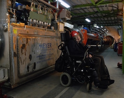 Stephen Hawking in front of a Meyer Tool custom cryogenic distribution box in the Large Hadron Collider at CERN